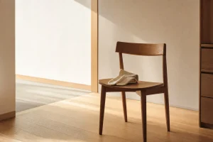 朝の光が差し込む部屋に置かれた木製の椅子と、その上の靴下